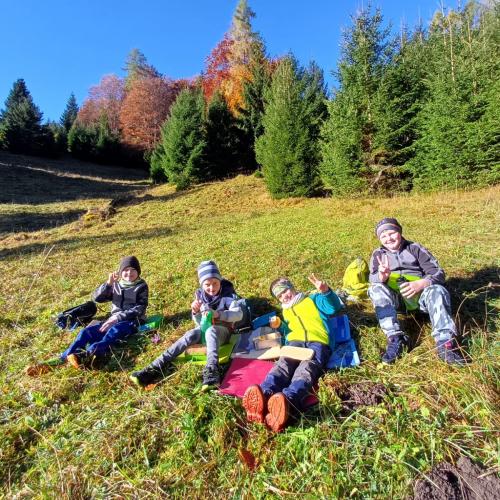 Kinder beim Jausnen auf einer Waldwiese