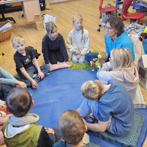 Die Zahngesundheitserzieherin erzählt den Schülern eine Geschichte im Sitzkreis