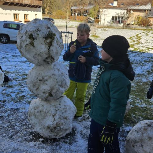 Schüler stehen um ihren Schneemann