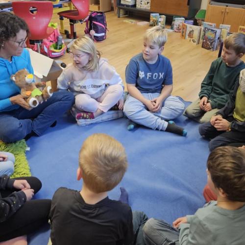 Die Zahngesundheitserzieherin erzählt den Schülern eine Geschichte im Sitzkreis