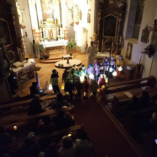Auf dem Bild sind Kinder mit Laternen in der Hand in der Kirche zu sehen