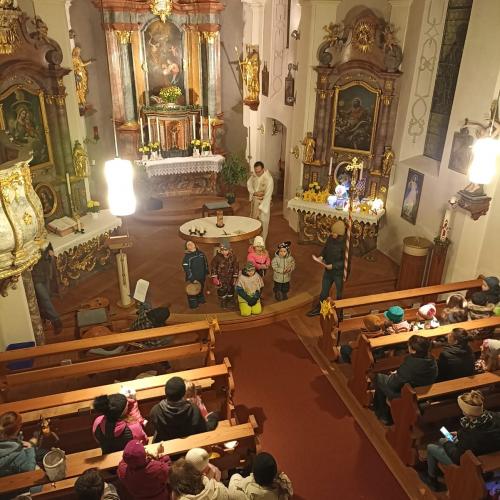 Auf dem Bild sind Kinder mit Laternen in der Hand in der Kirche zu sehen