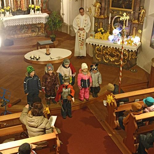 Auf dem Bild sind Kinder mit Laternen in der Hand in der Kirche zu sehen