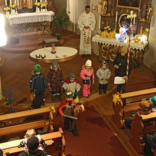 Auf dem Bild sind Kinder mit Laternen in der Hand in der Kirche zu sehen