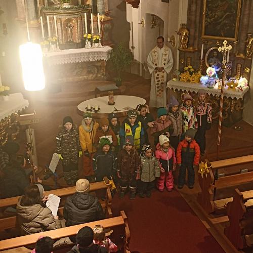 Auf dem Bild sind Kinder mit Laternen in der Hand in der Kirche zu sehen