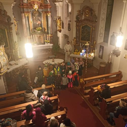 Auf dem Bild sind Kinder mit Laternen in der Hand in der Kirche zu sehen