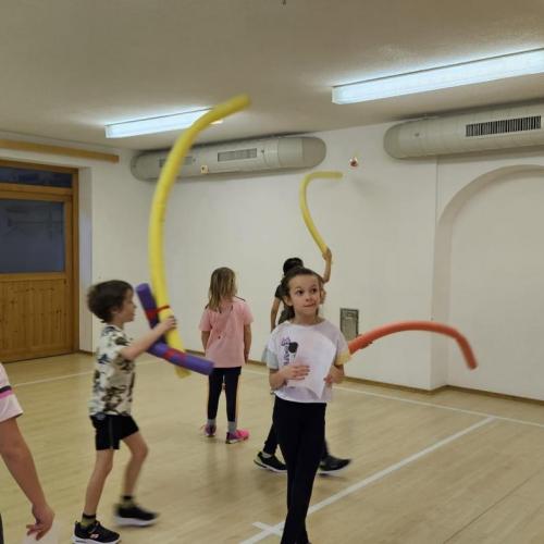 Schüler versuchen mit Badenudeln Obstbilder zu erreichen