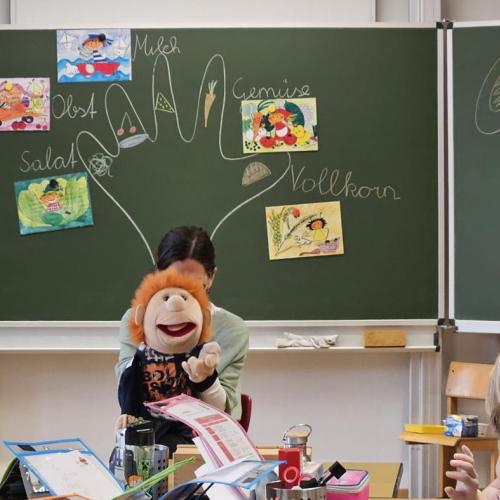 Eine Handpuppe unterhält sich mit den Schülern
