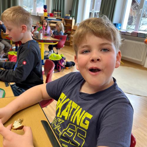 Kind beim Essen des Brotes mit Butter und Kräutersalz