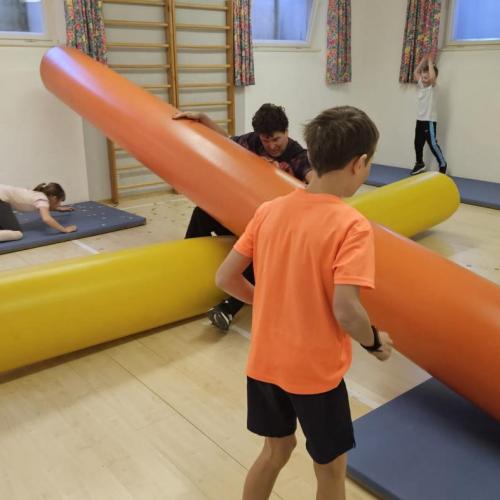 Schüler kriechen unter einer Rolle durch