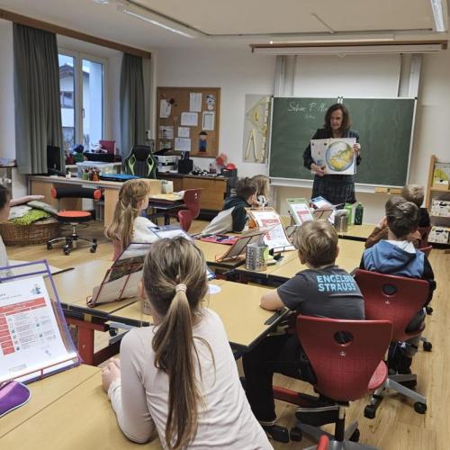 Autorin Sabine zeigt den Kindern auf der Karte, wo Dubai liegt.