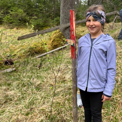 Kind mit seinem gepflanzten Baum