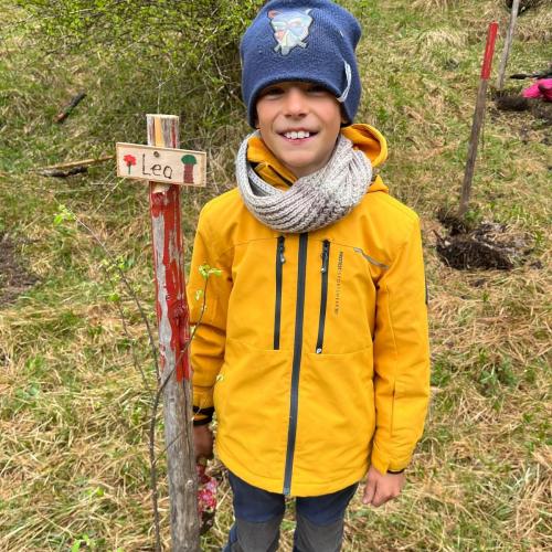 Kind mit seinem gepflanzten Baum