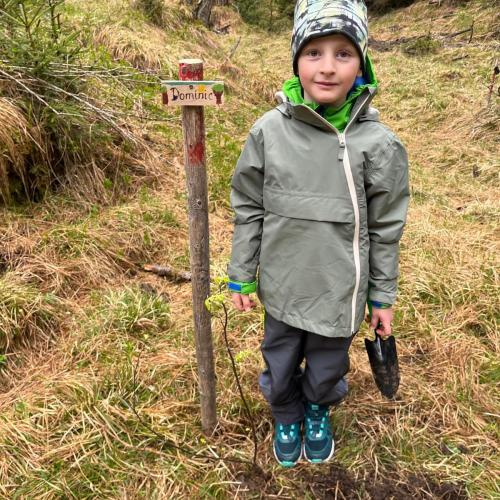 Kind mit seinem gepflanzten Baum