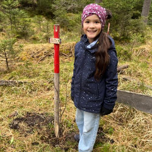 Kind mit seinem gepflanzten Baum