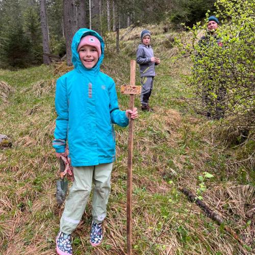 Kind mit seinem gepflanzten Baum