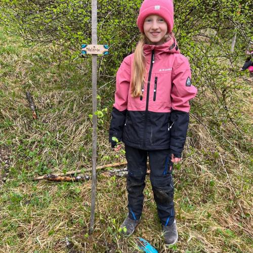 Kind mit seinem gepflanzten Baum