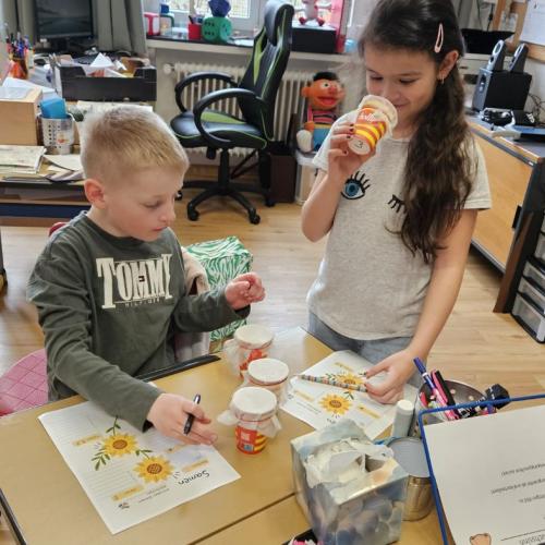 Schüler riechen an einem Becher mit Samen 