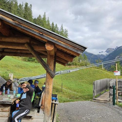 In einem Unterstand jausnen Schüler 