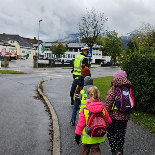 Ein polizist geht mit Schülern auf dem Gehsteig
