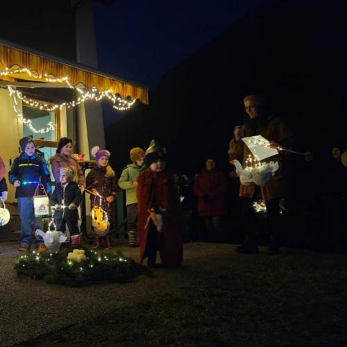 Kindergartenkinder und Volksschulkinder stehen mit ihren Laternen im Halbkreis