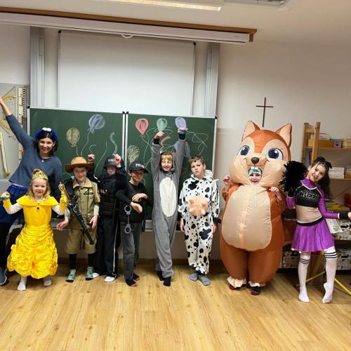 Verkleidete Schüler stehen vor der Tafel und schneiden Grimassen 