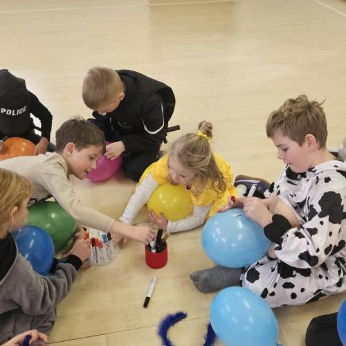 Schüler bemalen einen Luftballon