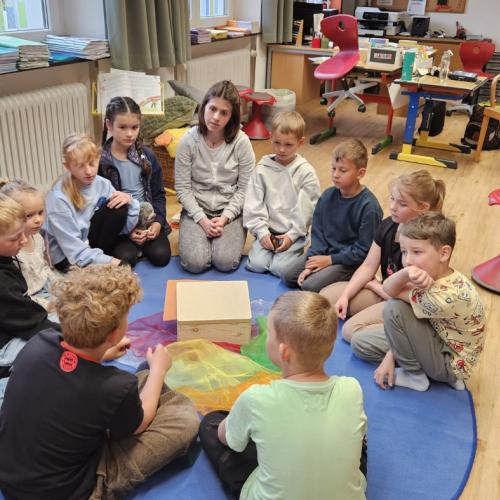 Annalena sitzt mit dem Schülern im Sitzkreis und bespricht ihr Projekt 