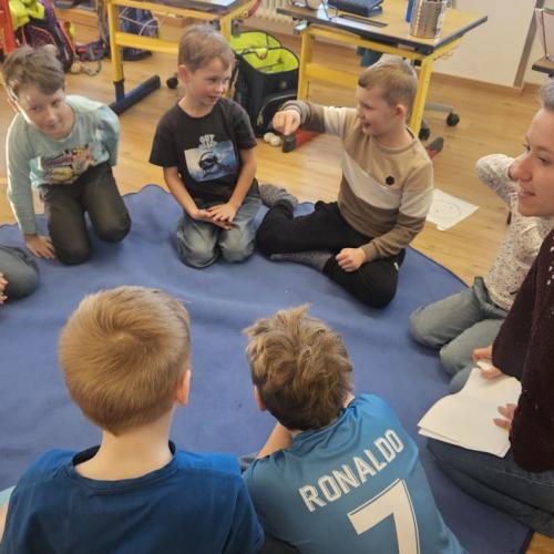 Die Praktikantin bespricht mit dem Kindern im Sitzkreis ihre Aufgaben