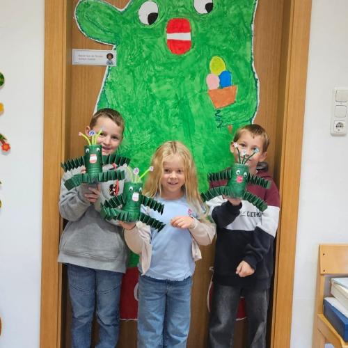 3 Schüler halten ein selbstgebasteltes Wir in der Hand