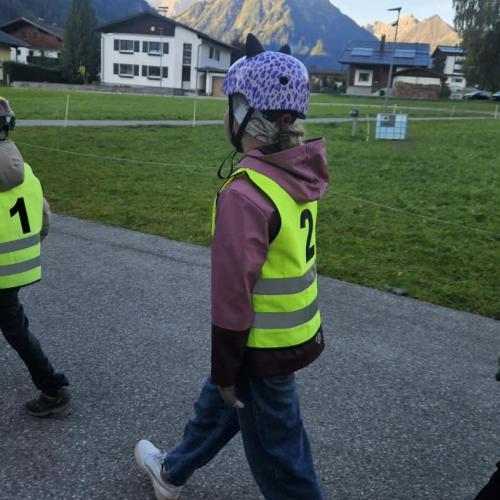 Drei Schüler mit Sicherheitsweste gehen hintereindander 