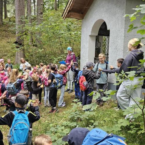 Die Schüler singen ein Lied vor einer kleinen Kapelle