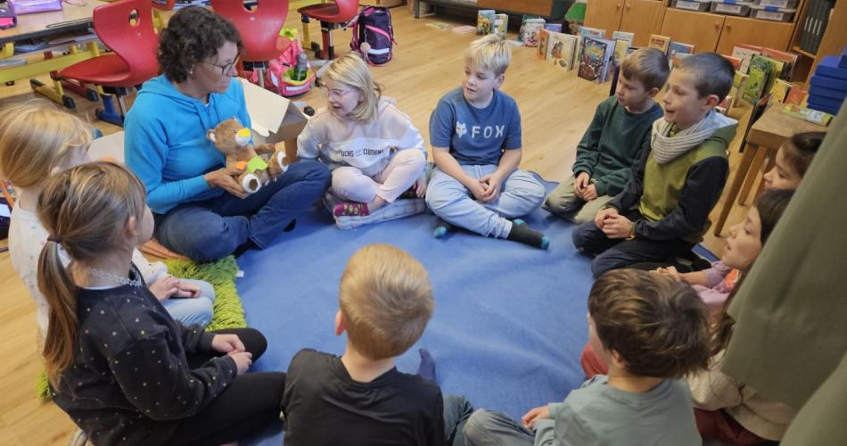 Die Zahngesundheitserzieherin erzählt den Schülern eine Geschichte im Sitzkreis