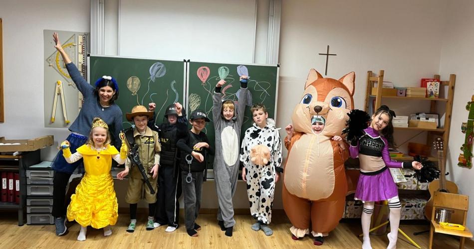 Verkleidete Schüler stehen vor der Tafel und schneiden Grimassen 